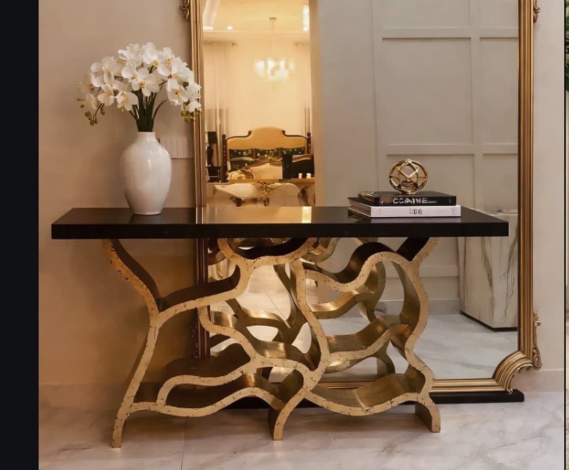 Aurelia console with sculptural brass base and black marble top